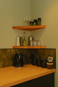 a kitchen with wooden counter top with glasses on shelves at The Whole Front House in Hapuku