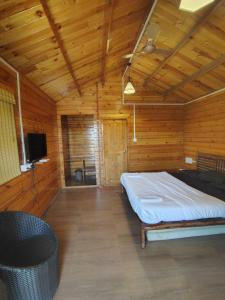 a bedroom with a bed in a wooden room at Cocorico Stay Ya! Cottages Alibag in Alibaug +17 photos