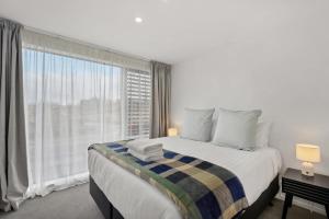 a bedroom with a large bed and a large window at Skyliine Serenity in Wanaka