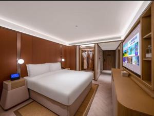 a bedroom with a bed and a flat screen tv at 北京奥体中心鸟巢桔子水晶酒店 in Beijing
