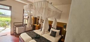 a bedroom with a canopy bed with white curtains at Hilltop Guest House in Ella