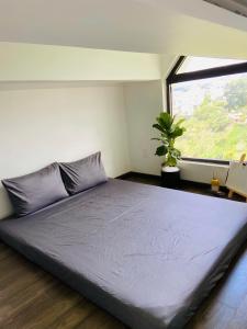 a large bed in a room with a window at Nắng's Villa & Coffee in Ấp Ða Lợi