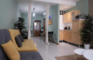 a living room with a couch and a kitchen at ApartHotel Verona Centro - Teatro Filarmonico in Verona