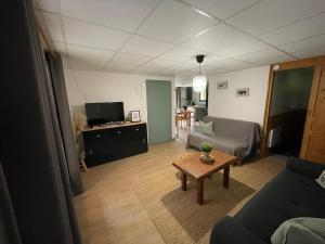 a living room with a couch and a table at Appartement 4 personnes - CHALET COSY Mont Dore in Le Mont-Dore