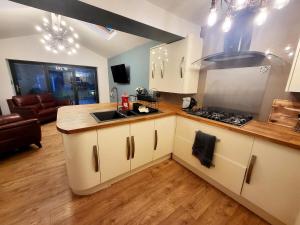 una cocina con fregadero y estufa horno superior en 3-Bed Family Haven with Free Parking, en Huddersfield