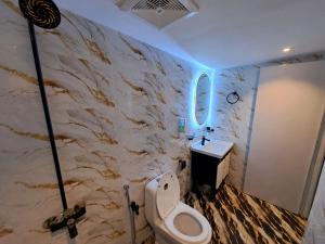 a bathroom with a white toilet and a sink at Pinewood Guest House, Islamabad in Islamabad +23 photos
