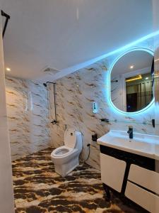 a bathroom with a toilet and a sink and a mirror at Pinewood Guest House, Islamabad in Islamabad