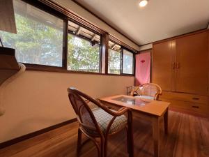 a kitchen with a table and chairs and windows at はたご屋ちゅうべ in Taki
