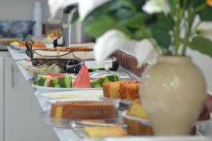 a buffet line with plates of food and a vase at Hotel Ideal in Teresina