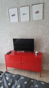 a red dresser with a television on top of it at Ferienwohnung Pitstop in Oschersleben