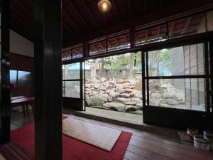 an open door to a room with a stone wall at はたご屋ちゅうべ in Taki