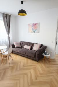 a living room with a couch and a wooden floor at Cinque Stelle Hotel Apartments in Cluj-Napoca +10 photos