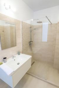 a bathroom with a white sink and a shower at Cinque Stelle Hotel Apartments in Cluj-Napoca +12 photos