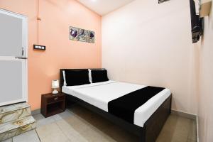 a bedroom with a black and white bed in a room at Super Hotel O Sofitel Hotel in Dhanbād