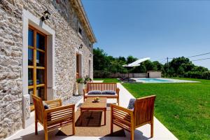 un patio con 2 sillas, una mesa y un patio en Casa Škitaconka, en Koromačno