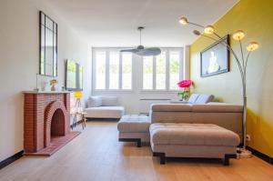 Una sala de estar con un sofá y una chimenea. en L'annexe, en Saint-Hilaire-sous-Romilly