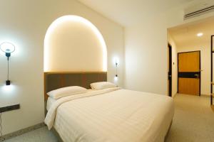 a bedroom with a white bed with a large orb above it at Evertree Hotel in Balikpapan