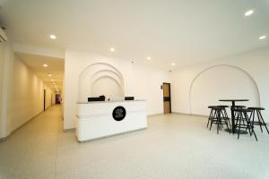 a lobby with tables and stools in a building at Evertree Hotel in Balikpapan