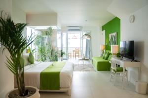 a bedroom with a large bed and a living room at Antana Hotel in Canggu