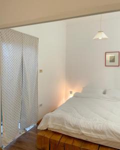 ハノイにあるNhiên House 2 Old Quarter 2nd floorの白いベッドルーム(ベッド1台、カーテン付)