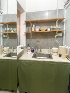 ハノイにあるNhiên House 2 Old Quarter 2nd floorのキッチン(緑のキャビネット、シンク付)