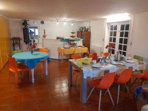 a living room with two tables and orange chairs at Valença Guesthouse in Valença
