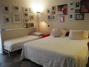 ジェノヴァにあるALTIDO Dimora Palazzo Serraのベッドルーム1室(ベッド2台付)が備わります。壁には絵画が飾られています。