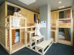 two people in a room with wooden bunk beds at métisse stay in Nanto
