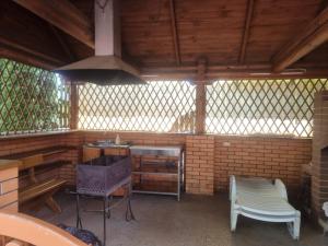a screened in porch with a stove and a chair at Бухта Вікінга in Szack