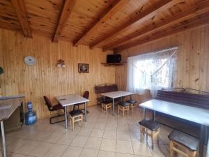 a dining room with tables and chairs in a cabin at Бухта Вікінга in Szack