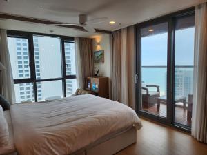 釜山premium ocean view in HAEHUNDAE BONA TRAVEL的一间卧室设有一张床和享有美景的大窗户 更多31张照片