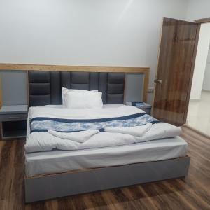 a bedroom with a large bed with a black headboard at The Elements guest house in Leh
