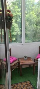 a room with two benches and a table and two windows at Coco Apartment in Dobrota
