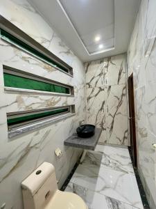 费萨拉巴德Elysian Nest 2BR Apartment Abdullah Gardens的带马桶和玻璃淋浴间的浴室 更多13张照片