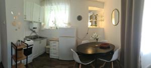 a small kitchen with a table and a refrigerator at Coco Apartment in Dobrota +6 photos