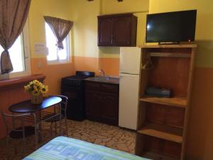 a small kitchen with a small table and a television at Hotel Las Salinas in Zihuatanejo