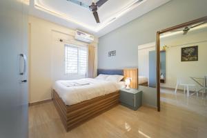 a bedroom with a bed and a large mirror at Stayhomestays Grande in Bengaluru