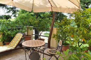 patio ze stołem, krzesłami i parasolem w obiekcie Relais des Roches w mieście Sona