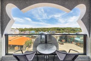 a balcony with chairs and a view of a city at 北極熊旅店 in Xiaoliuqiu +146 photos