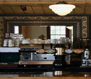 a mirror in a kitchen with a reflection of a person at Opononi Hotel in Opononi +7 photos