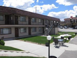 an apartment building with a patio and a table and chairs at Bristlecone Motel in Ely