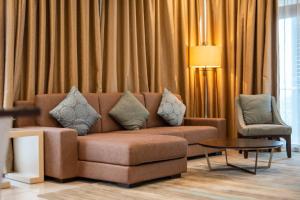 Iskandar PuteriにあるSpacious 3BR Somerset Suite in Puteri Harbourのリビングルーム(ブラウンソファ、テーブル付) +50枚の写真