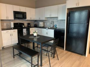 una cucina con tavolo e frigorifero nero di Harbor Haven, Just 2 miles from Beale! a Memphis