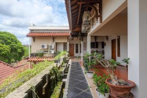 einen Balkon eines Hauses mit Topfpflanzen in der Unterkunft Urbanview Omah Eka Santi by RedDoorz in Yogyakarta
