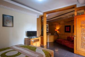 ein Schlafzimmer mit Bett und ein Wohnzimmer in der Unterkunft Urbanview Omah Eka Santi by RedDoorz in Yogyakarta