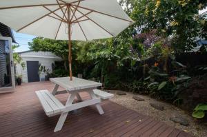 a picnic table with an umbrella and a bench at Bungalow Eight - 1930s charm near Pukekura Park in New Plymouth