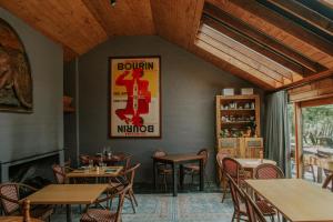 a restaurant with tables and chairs and a poster on the wall at Crackenback Farm Guesthouse in Crackenback