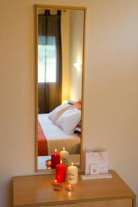 a bedroom with a mirror and candles on a table at Elia Houses in Koutsounari
