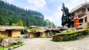 een resortgebouw met een berg op de achtergrond bij Guci Heritage Hotel in Tuwel