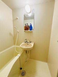 a small bathroom with a sink and a bath tub at 華宝民泊1 in Osaka